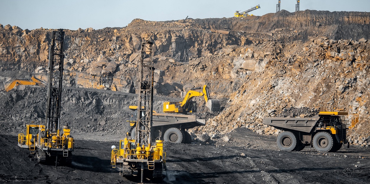 Drilling machine borer installing cast explosives blasting. Open coal mine.